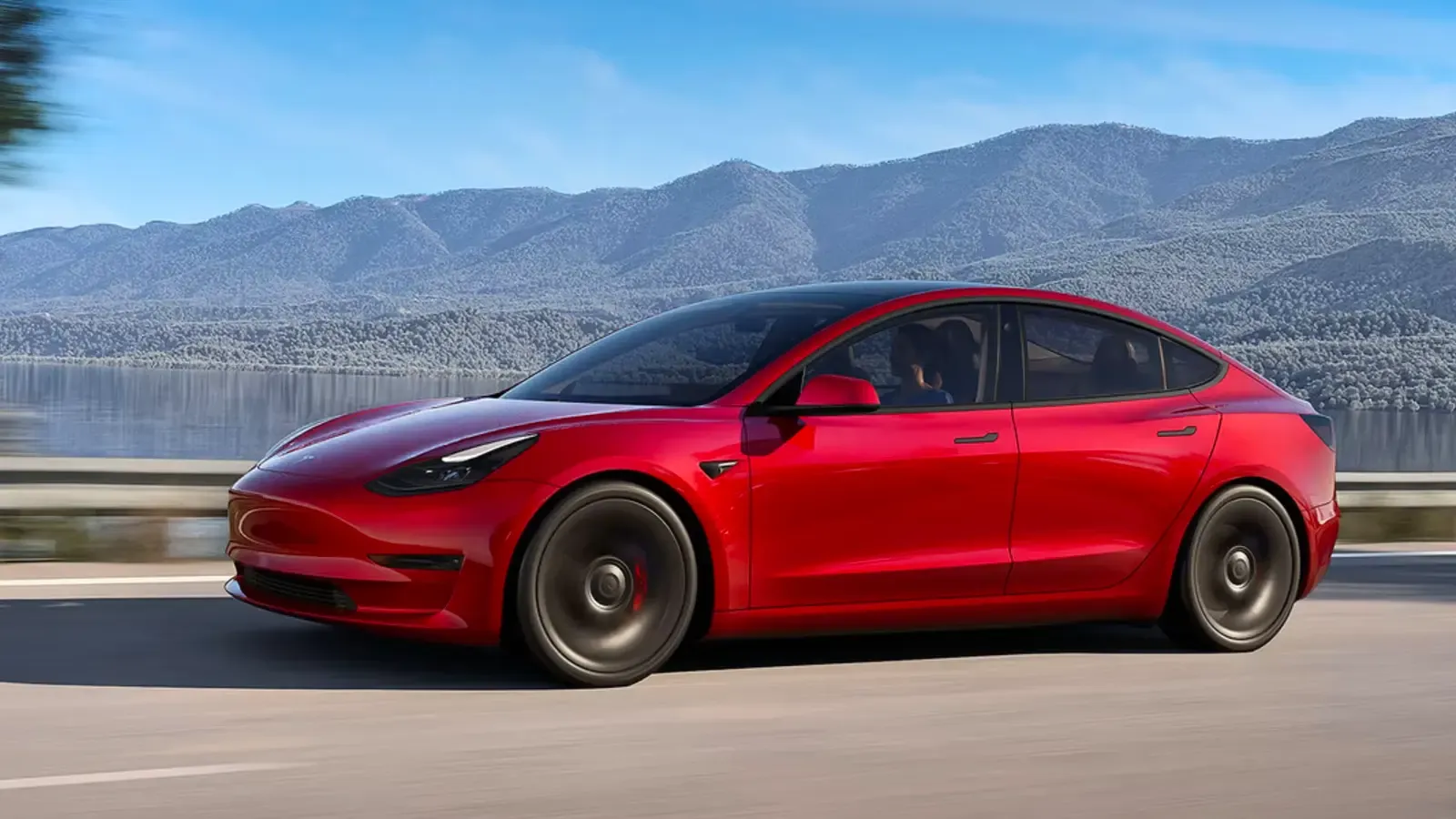 Tesla Model 3 in red driving on the road