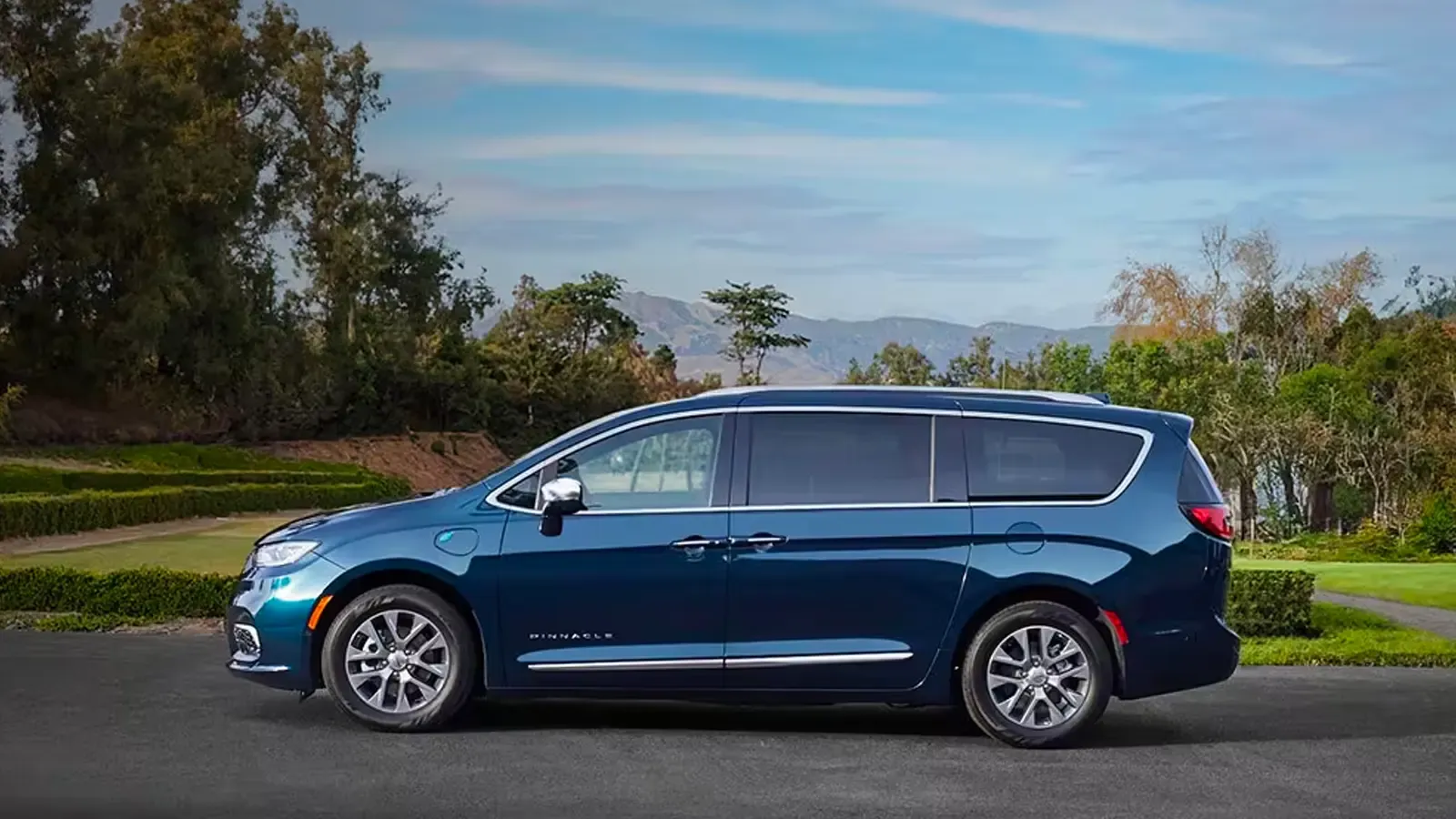 Chrysler Pacifica Hybrid side profile in a cobalt color by mountains
