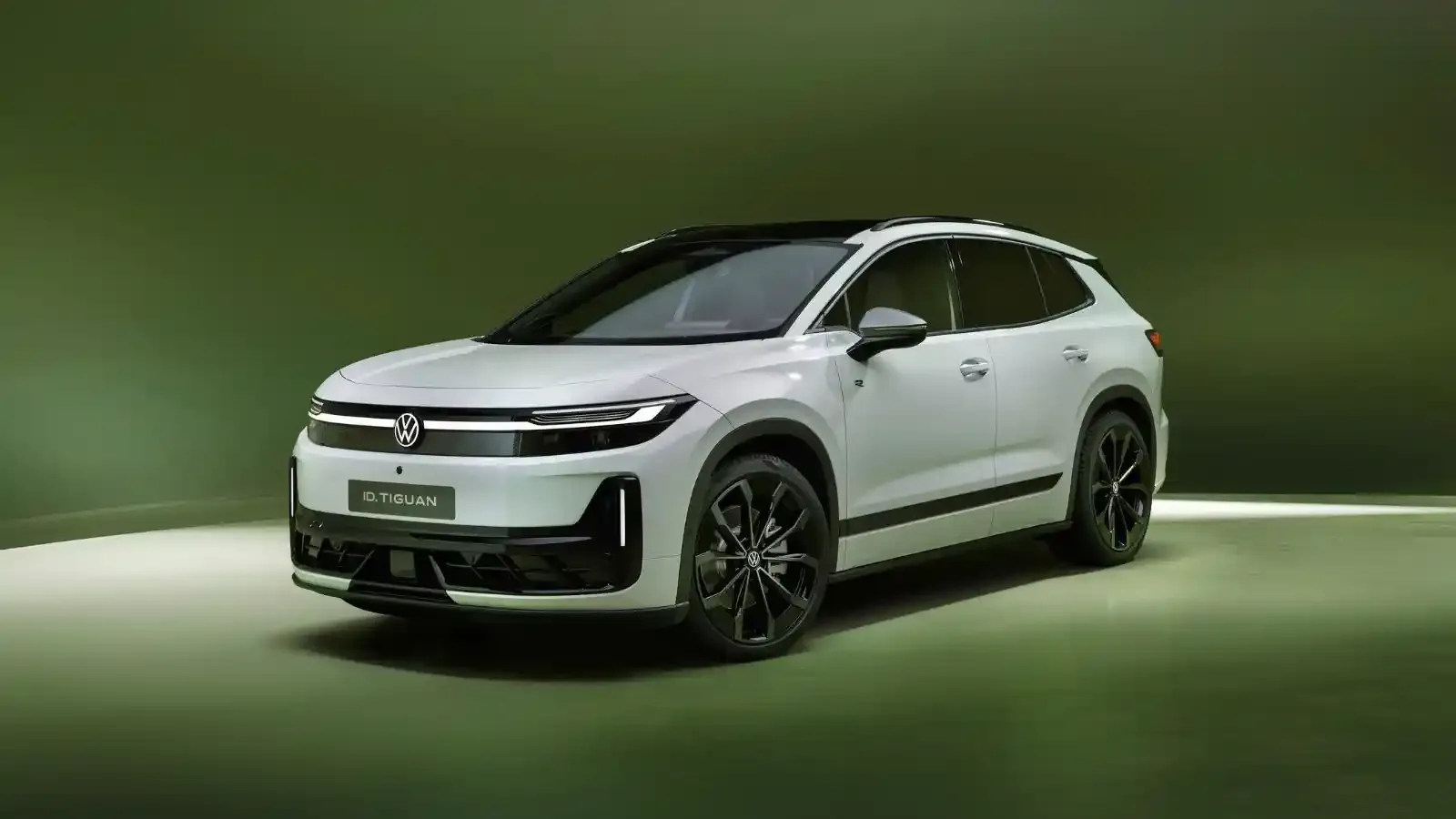 White Volkswagen ID. Tiguan sitting at an angle on a platform with a green surrounding background